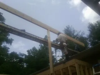 Carpenter setting a ridge beam over a new addition frame — Ice Dam Removal by Roofing Brothers in Cherry Tree
