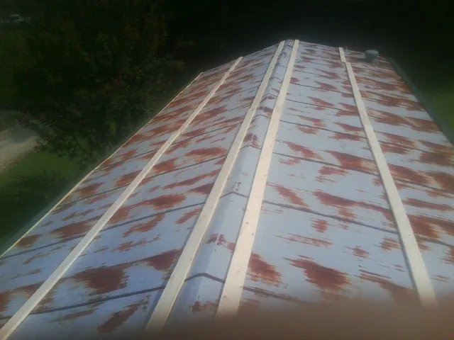 Rusted metal roof panels with new wood purlins before replacement — Storm Damage Roof Repair in Cherry Tree by Roofing Brothers