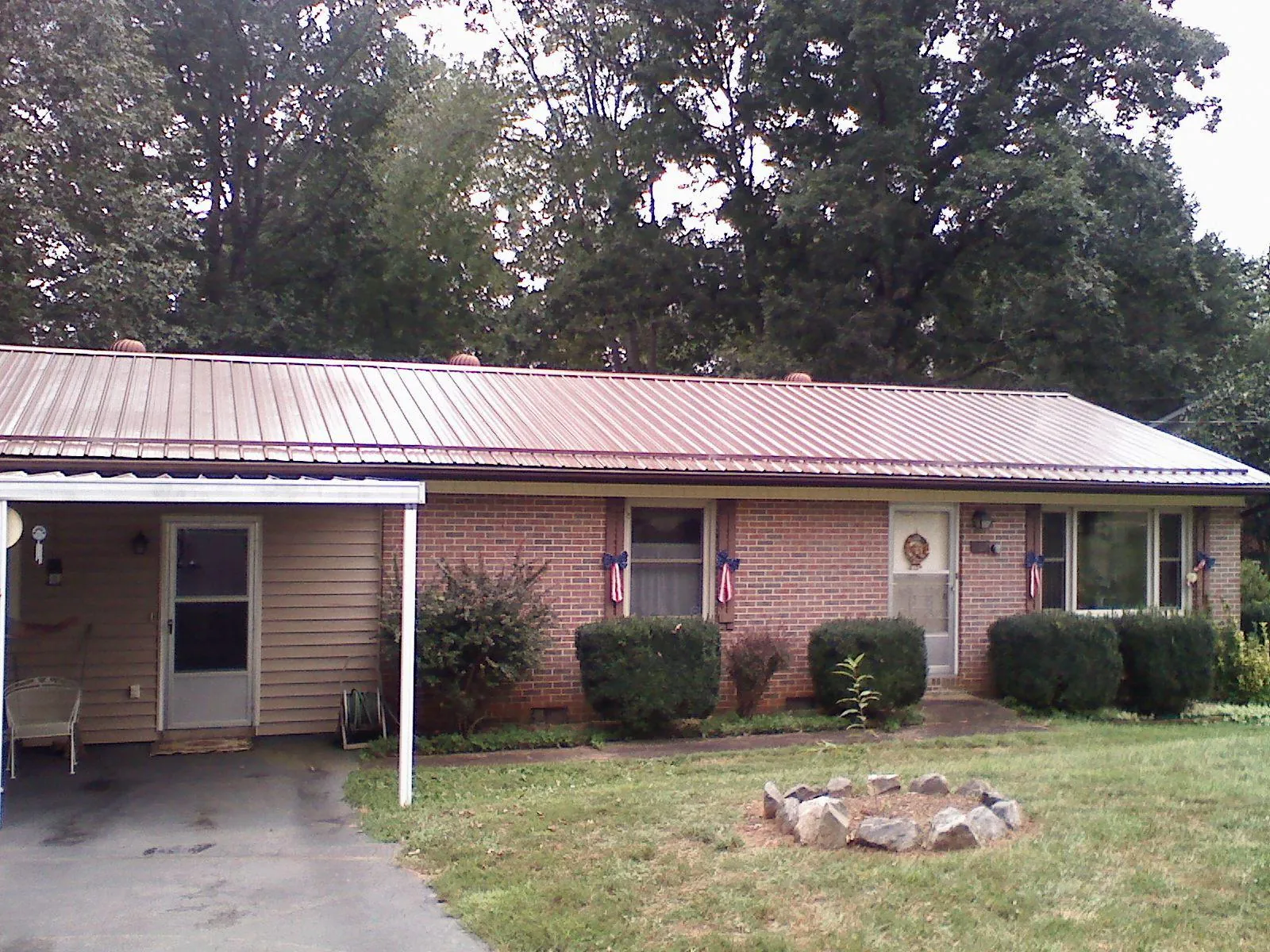 Bronze metal roof and carport on a brick ranch home — Roof Repair work by our crew in Cherry Tree